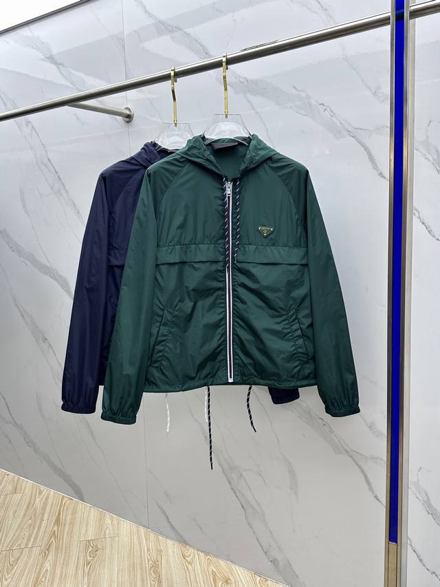 Prad*普拉达 25Ss新款受科技服饰启发的短夹克具有轻盈、运动的设计，并以精致的风格重新诠释了功能性细节。该服装采用再生尼龙制成，这是一种象征性的Prada