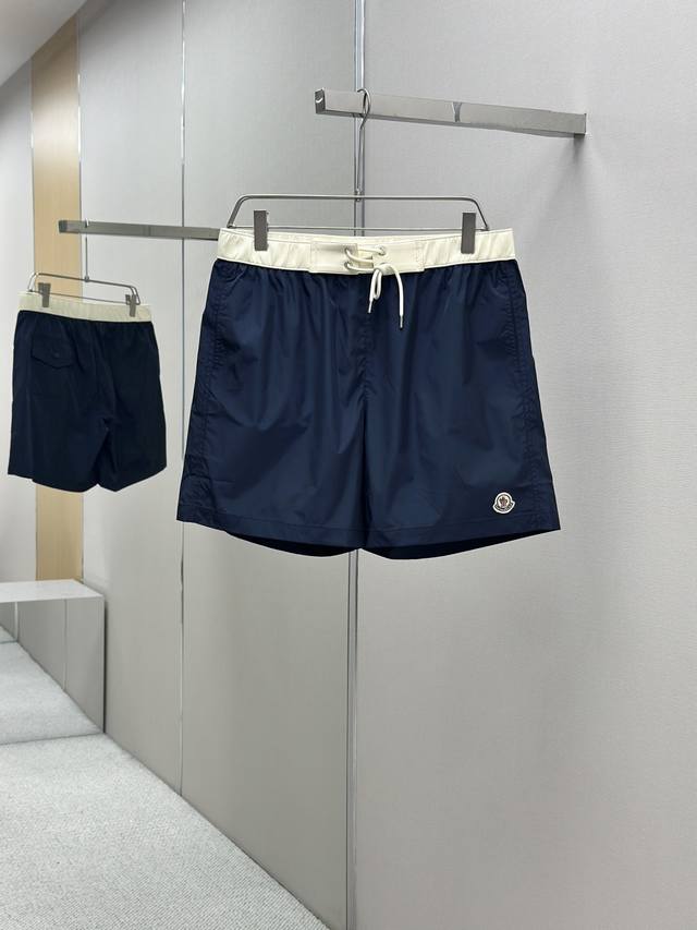 Moncler 徽标抽绳沙滩短裤 工艺说明：面料采用精选优质聚酯纤维，面料不仅柔软亲肤，穿在身上就像被云朵轻轻包裹，而且透气性绝佳，夏天穿完全不会觉得闷热，整体