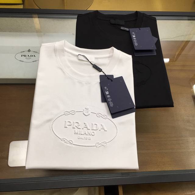 新品 Prad... 2025春夏新款首发专柜最新款圆领短袖 高端订制 设计前卫时尚！品牌Logo重工艺设计 高端定制100支双面丝光棉面料.手感柔软.穿着舒适