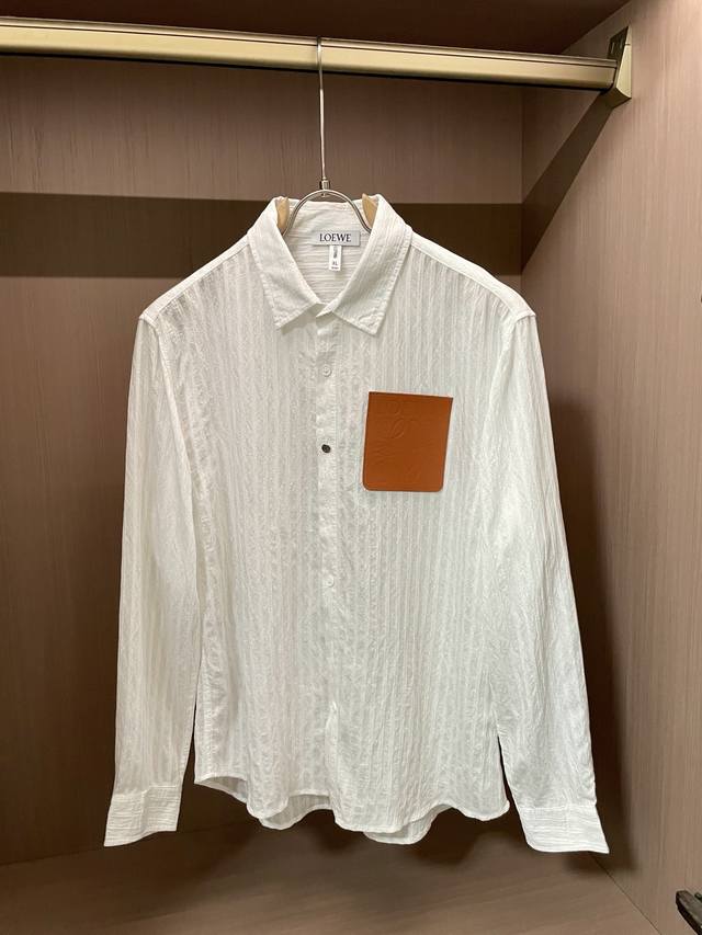 Loewe 长袖衬衫，胸前皮质压纹标超有辨识度，微皱肌理自带慵懒感。单穿简约高级，叠穿也能当层次感担当，轻松拿捏低调奢华～ 尺码M-Xxxl