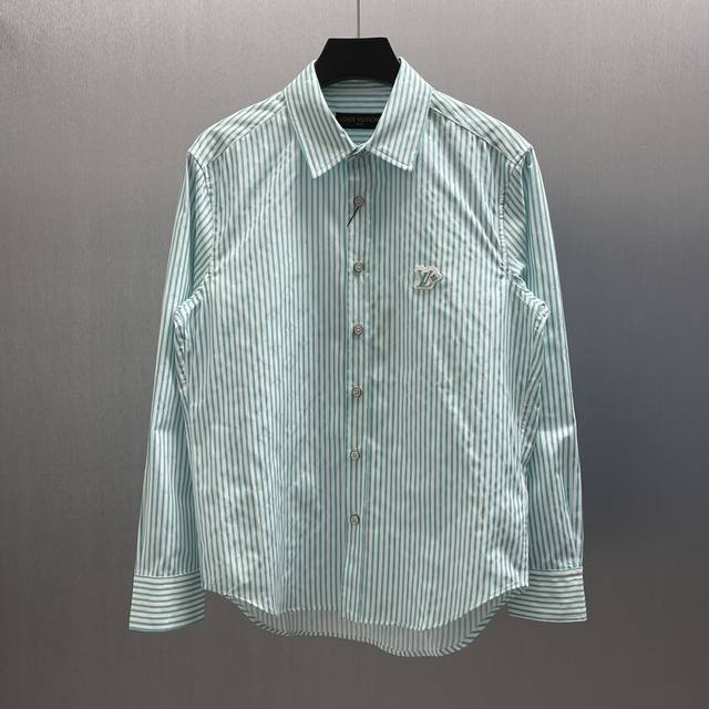 Lu 标识提花绿条纹衬衫 Size : S-Xl 本款棉质长袖衬衫以 Monogram 提花铺陈背景，再借明媚条纹印花丰富视觉层次。胸前I Flower 橡胶贴