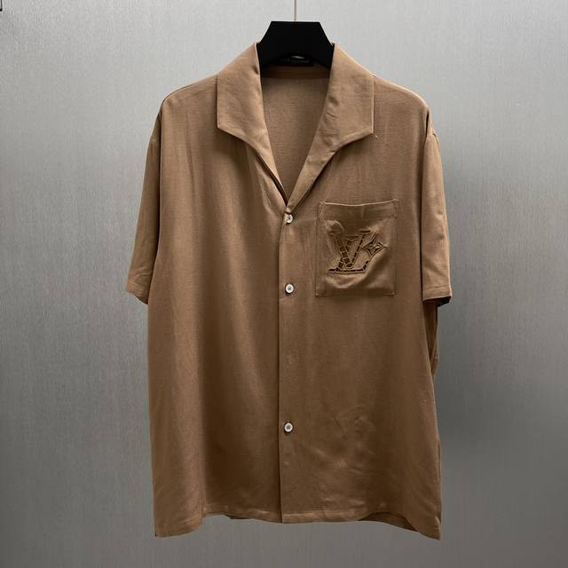 Lu 棉麻蚕丝绣夏日衬衫 Size: S-Xl 本款村衫选用桑蚕丝和大麻混纺，呈现山东绸一般的细腻肌理。英式刺绣工艺于胸前口袋勾勒镂空标识，开领短袖剪裁传递夏日