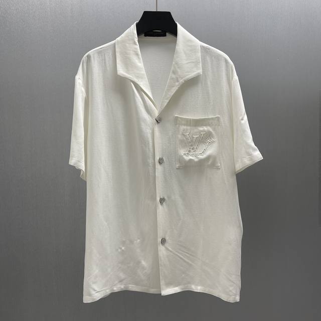 Lu 棉麻蚕丝绣夏日衬衫 Size: S-Xl 本款村衫选用桑蚕丝和大麻混纺，呈现山东绸一般的细腻肌理。英式刺绣工艺于胸前口袋勾勒镂空标识，开领短袖剪裁传递夏日