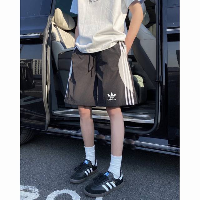 Adidas 阿迪达斯三叶草 夏季经典三条杠条纹撞色拼接速干运动短裤五分裤沙滩裤 今年最流行面料 上身非常简单帅气有型的一款 男女情侣款都能轻松驾驭. 面料质感