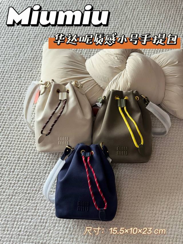 缪缪 华达呢水桶包 永恒经典 匠心配色 米白温柔 靛蓝深邃 军绿飒爽三色皆高级，适配所有穿搭场景 精工细节 原版定制帆布 挺括有型+珍珠光泽感 立体刺绣Logo