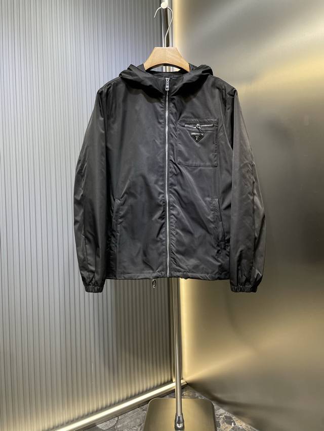 Prada 顶级原单 三角标拉链连帽夹克定制韵致绒锦斜纹缎 质感卓越 舒适贴肤 经典黑色调散发与生俱来的高级感 标志性Prada三角标点缀胸前 彰显品牌魅力 加