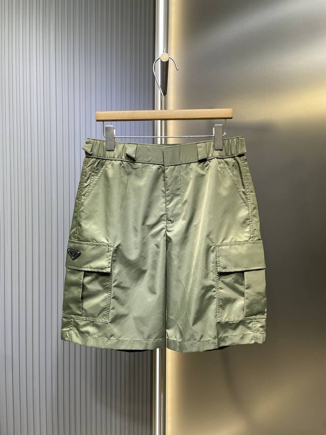 Prada 顶级原单 尼龙双口袋工装短裤面料：采用40支100%尼龙面料，该款面料做有过胶工艺，成衣效果版型非常立体。工艺：该款尼龙短裤采用特种机做出成品，多针