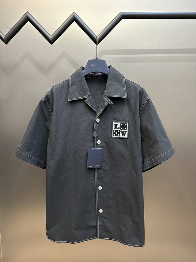 Lv 雪花绒贴章衬衫面料采用40S*40S全棉平纹布，胚布预缩后做磨毛工艺，缸内染色洗水定型出成品布，成品布重新进缸做砂洗工艺，将表面棉絮进一步洗松散，面料表面