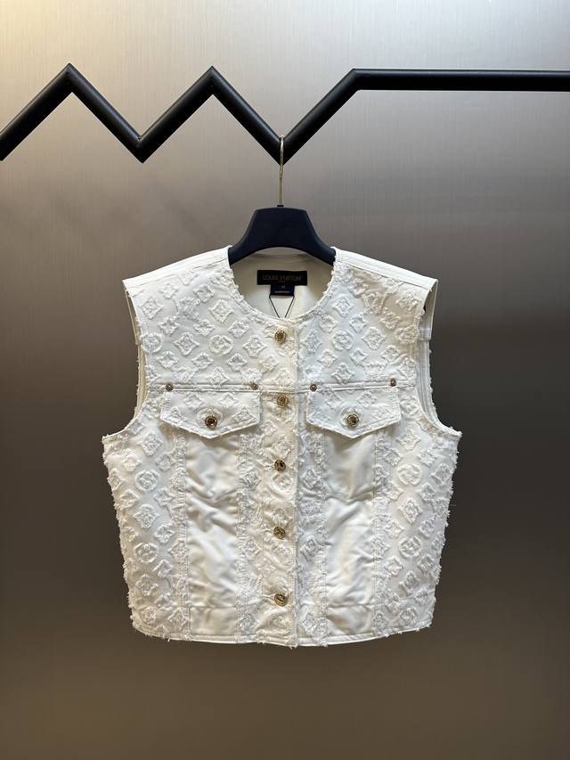 Lv Monogram 剪花无袖牛仔马甲本款无袖夹克选用素净丹宁布裁出闲雅箱型廓形，以剪花 Monogram 图案烘托丰盈肌理。肩部和翻盖口袋的别致嵌饰丰富结构