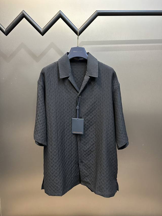 Lv 暗纹皱感老花衬衫采用涤棉混纺提花面料，经纱采用20D涤纶超细纱，牵引经纱上轴做提花盘头，特种高速剑杆提花机织造胚布，纬纱采用棉纱+低弹丝加捻制成特种纱线，
