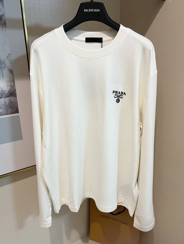 Size S M L Xl 2配色：黑色 白色 男女同款 Prada 本款棉质长袖 T 恤以当季色调传递典雅韵味，成就日常搭配佳选。左侧刺绣含蓄标注品牌身份，字