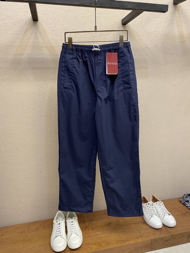 Gucci饰字母徽标棉府绸长裤面料选择：选用棉纤维以经纱两倍于纬纱的平纹织法，形成表面细密、均匀的菱形颗粒纹理，触感光滑且略带光泽感的棉府绸面料。纯棉材质吸湿透