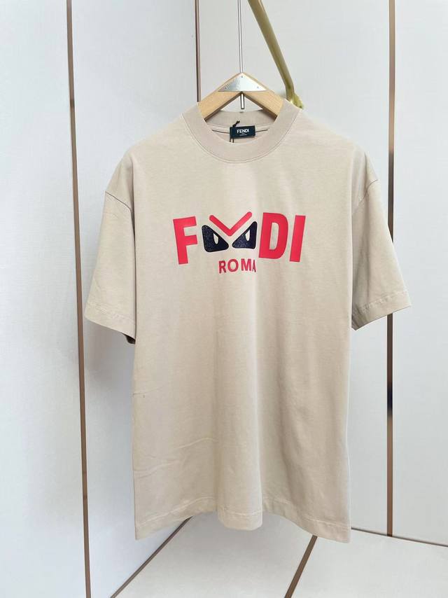 芬迪2025新款小怪兽图案T恤 “Fendi”品牌标志部分字母“F”“D”，中间“E”被设计成一对黑色的类似怪兽眼睛的图案，眼睛上方有一道红色线条，右侧是红色的
