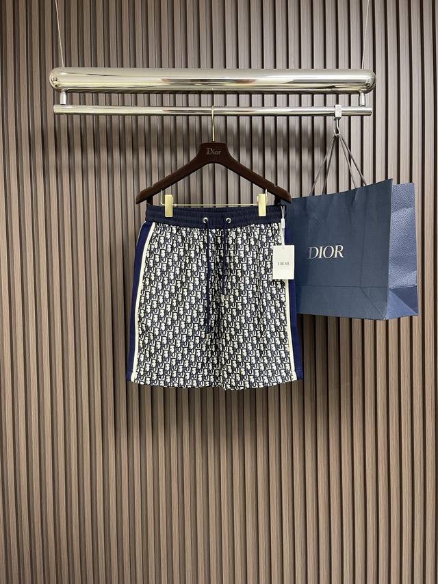Dior 经典老花藏蓝色提花休闲短裤，这款短裤采用聚酯纤维与棉混纺面料，巧妙融合两种材质优势。棉纤维带来绝佳的亲肤感与吸湿透气性，让肌肤时刻保持干爽舒适；聚酯纤