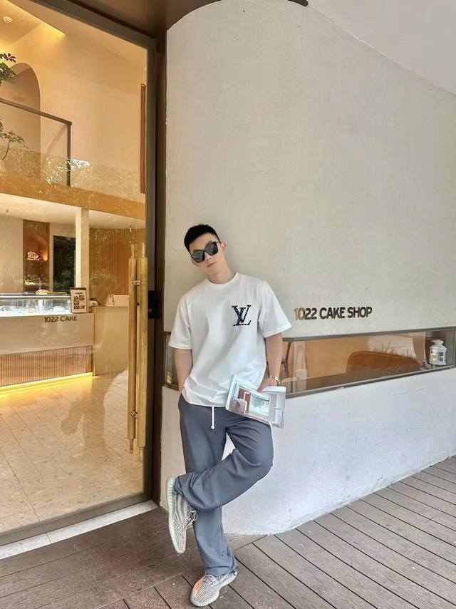 Lv牛仔老花标识白色短袖T恤 经典与时尚碰撞，路易*这款白色短袖瞩目登场。标志性牛仔老花“V”标识，巧妙缀于胸前，复古韵味与潮流格调交融，瞬间成为视觉焦点。后背