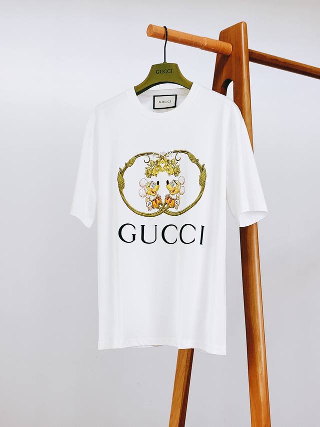 Gucci 古驰 2025Ss春夏新品联名限定T恤，将童趣与奢华巧妙融合。胸前印花，以精致工艺呈现：标志性双 G 框架勾勒，金色藤蔓缠绕，灵动又复古。米奇形象融