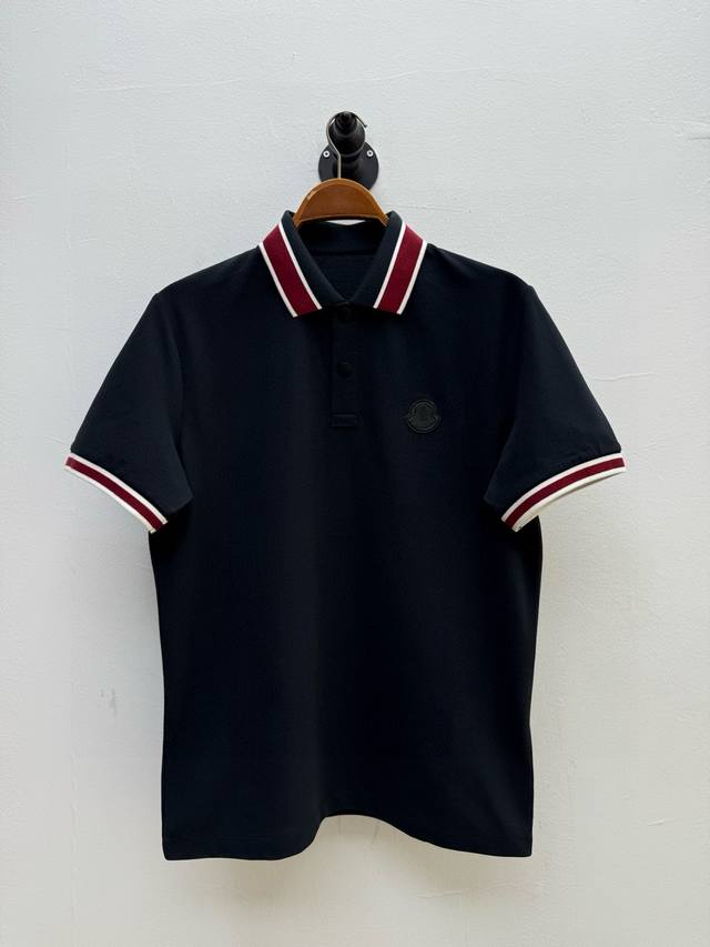 Mon 嵌边织带装饰Polo衫、代工厂P出品 春夏系列经典的翻领设计，搭配领口对比色嵌边，提升视觉层次感，胸口饰有双层小牛皮徽标，采用热压工艺，保留了原始皮纹肌
