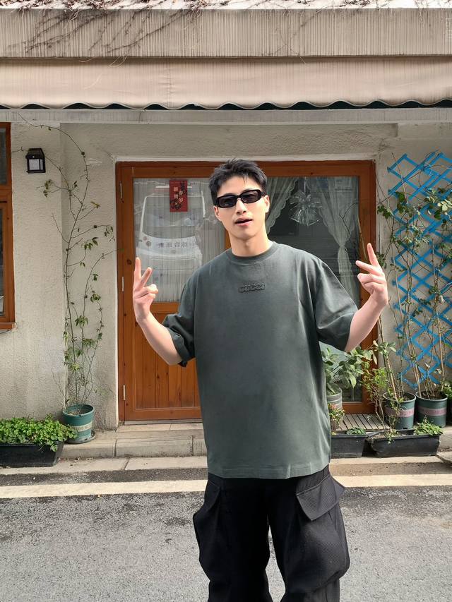 Gucci 标识刺绣短袖 定染雅致墨绿丝绵 柔软细腻 舒适贴肤 以深邃的墨绿色调为底蕴 宛如森林深处的静谧 胸前醒目的Gucci字样点缀其间 如同品牌精神的烙印
