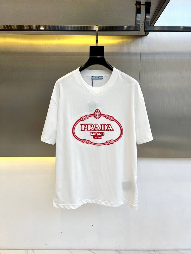 G Prada 普拉、2025男士徽标印花平纹针织T恤短袖。这款平纹针织T恤采用方正廓形，搭配长袖与罗纹针织圆领。撞色印花徽标打造令人眼前一亮的款式，标志性织物