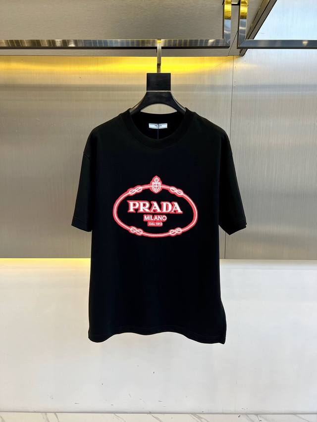 G Prada 普拉、2025男士徽标印花平纹针织T恤短袖。这款平纹针织T恤采用方正廓形，搭配长袖与罗纹针织圆领。撞色印花徽标打造令人眼前一亮的款式，标志性织物