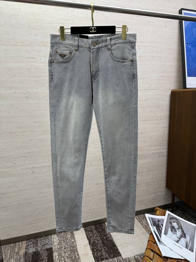 Pra25S春夏男士直筒牛仔裤 棉质牛仔面料打造 质地柔软又不失筋骨，手感干爽有韧性 经典的标志性浮雕徽标，灵魂般的点缀 各项指标皆为上品，自然带来极佳的上身体