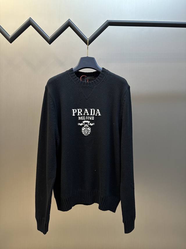 Prada 提花圆领毛衣 定织韵55°绒奢羊绒毛料，标志性Prada徽标以提花方式醒目呈现，与领口三角区拼接独特设计相得益彰增添品牌辨识度，遵循了Prada一贯