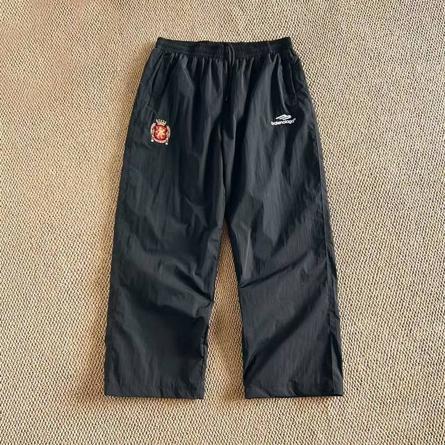 Balenciaga丨巴黎世家 24Ss 联名曼联足球运动长裤 高立领插肩袖双头拉链开合2个拉链斜口袋同系配色滚边细节 松紧袖口和腰围胸部饰以Football