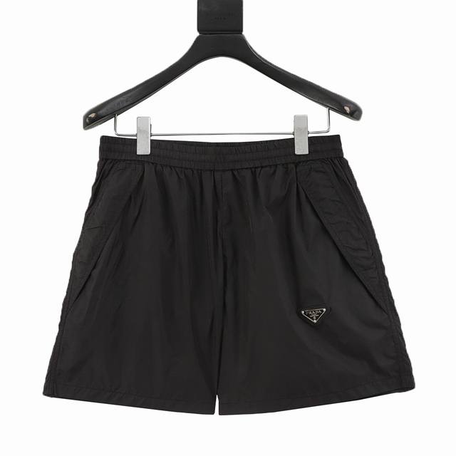 Prada 普拉达 经典口袋三角徽标沙滩短裤 夏季渠道限定沙滩短裤，定制定染尼龙面料，胸前口袋三角标五金点缀，作为整条裤子的点睛之笔，更具个性高级，宽松的阔腿裤
