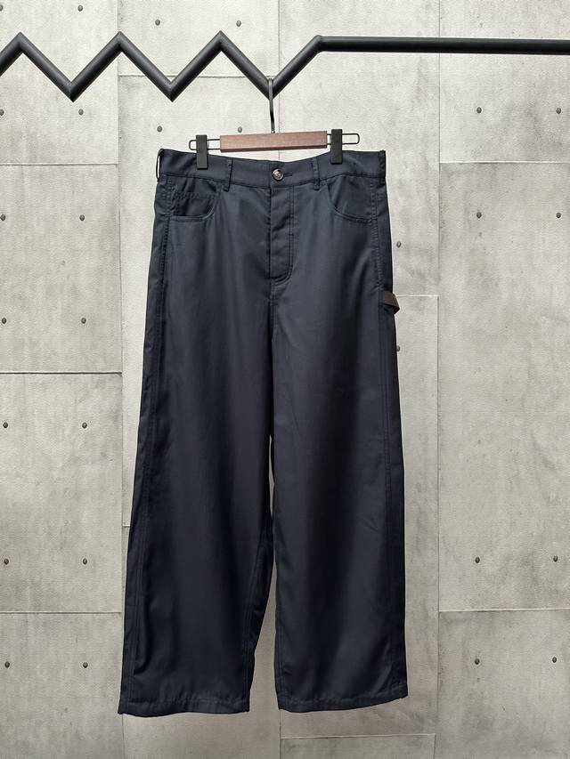 Loewe棉质斜纹布工装长裤 面料选择： 选用选用100%棉打造而成的轻盈棉质斜纹布面料。梭织机通过梭子在经纱和纬纱之间穿梭，形成斜纹布的斜向纹路。棉质材质使其