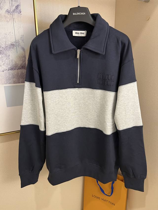 Size ：S M L Xl颜色：藏青色 灰色 2025Ss同款贴布刺绣拼色翻领长袖卫衣 谁懂啊！最近被Miu这件拼色Polo领卫衣种草了～真的是太绝啦！ 面料