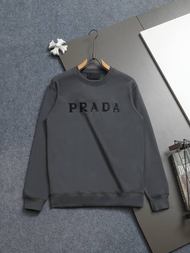 Prad*微宽版型 普拉达 25Ss新款胸前亮片圆领卫衣，这款卫衣融运动风极简主义设计和精美细节于一身。拼接了进口家独家布料，前胸的Prada 涂珐琅金属徽标充