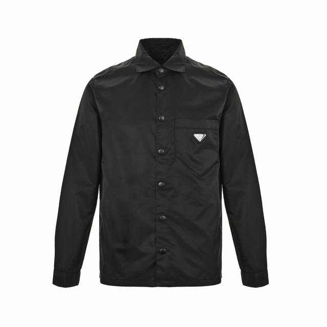 Prada 普拉达 尼龙三角标衬衫夹克外套 选用品牌标志性的再生尼龙面料，与传统尼龙性能相当，具备高强度，抗撕裂，耐磨损等特性。其质地轻盈，同时又具备防水功能适