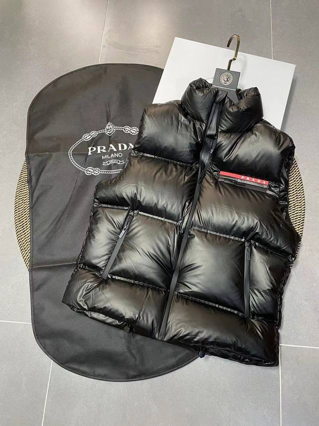 Prad* 普拉达 Fw最为昂贵的一款羽绒马甲背心 这款采用国内客供顶级的尼龙织物面料 面料表面的光泽感极强色泽油亮，尼龙织物的材质柔软手感巨好。全身防水压胶工