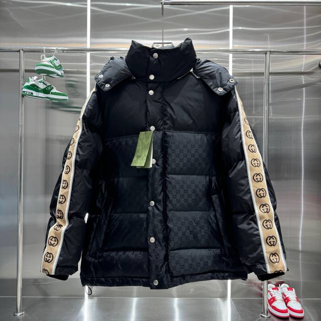 Gucci 古驰反光织带羽绒服 男女同款 Gg织带新元素暗双G 黑色立领羽绒大衣，采用尼龙塔夫绸绗缝设计，衣身缀有同色徽标。可拆卸式抽绳兜帽，正面隐藏式双向拉链