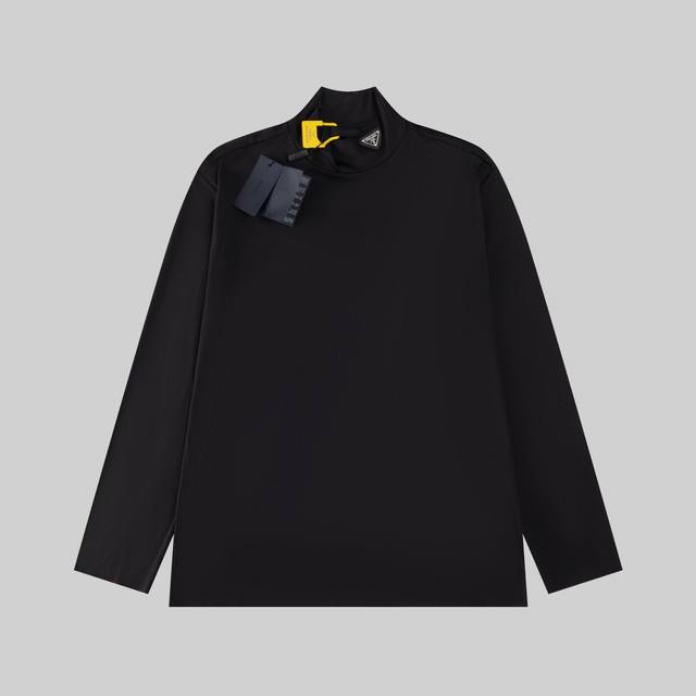 高版本 Prada 三角皮标高领打底衫 面料：采用60支高弹双面80 20棉面料. 辅料：三角标底部采用软牛皮材料，面部采用不锈钢材料电镀结合逢成. 工艺：该款
