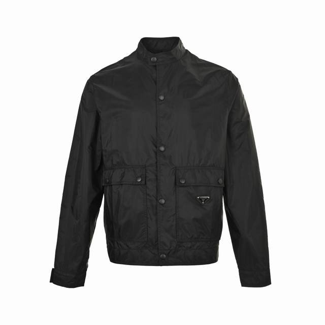 Prada 普拉达 25Fw 翻盖口袋暗扣再生尼龙立领夹克外套 选用品牌标志性的再生尼龙面料，与传统尼龙性能相当，具备高强度，抗撕裂，耐磨损等特性。其质地轻盈，