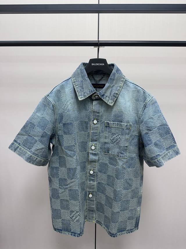 Louis Vuitton 棋盘格牛仔短袖衬衫 采用品牌标志性的3D Damier提花织纹面料，将Marque L.Vuitton DéPoséE标识巧妙融入纹