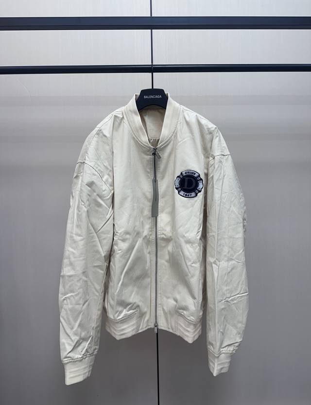 Dior 1947徽章立领棒球服外套 定制棉质帆布混纺面料，前胸D字植绒章仔图案，后背呼应同色系Logo字母刺绣，针织罗纹衣领衣袖下摆，金属拉链开合门襟，内里品
