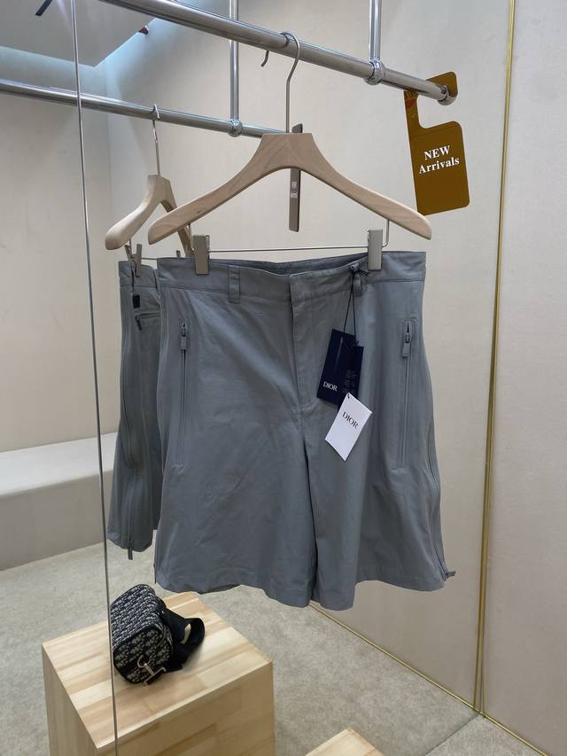 主推 Dior短裤原版开模，采用灰色棉质混纺面料制作，带有侧面和后侧拉链口袋，侧面展示三角形衬料设计，背面以Dior橡胶补丁、非常具有独特性，更能展现出夏季清新