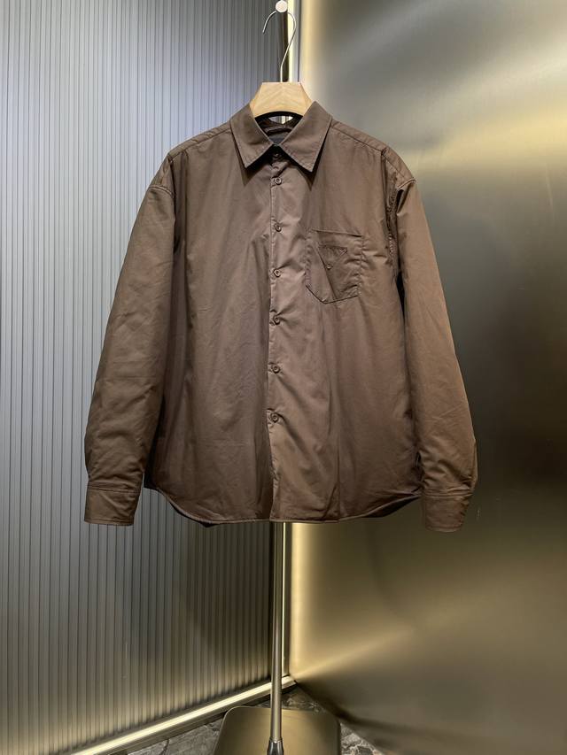 Prada 普拉达 25新款三角标尼龙翻领棉服外套 采用100%环保舒适的再生尼龙面料 。色牢度和稳定性更高，全新Ecol再生尼龙，现在并用于制作全新再生尼龙系