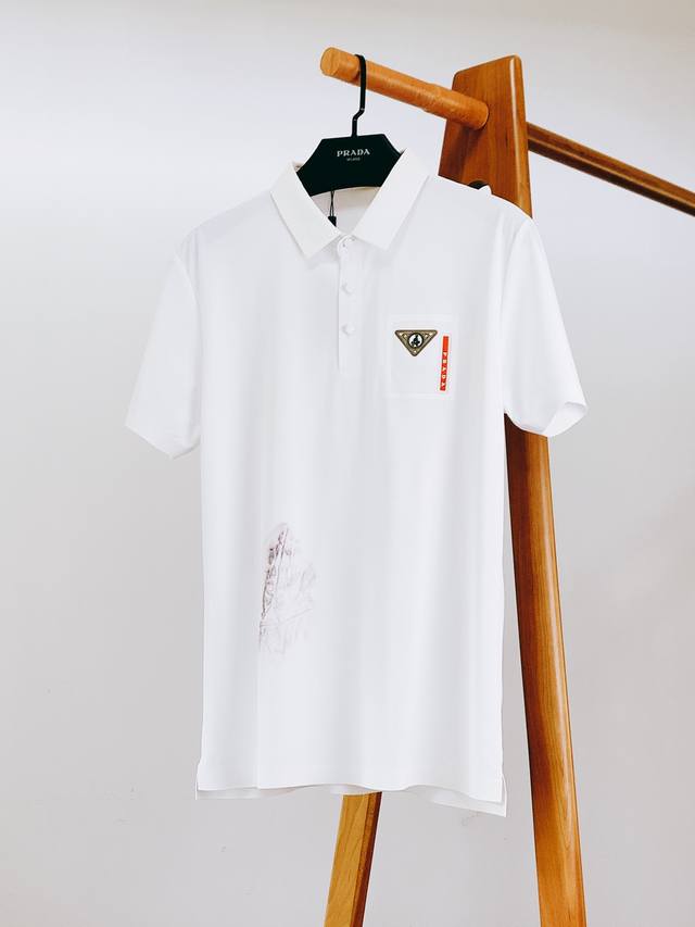 Prada 普拉达 2025Ss春夏新品 休闲翻领Polo衫。挺括的翻领，有着极佳的塑形效果，无论穿着多久，都不易变形塌陷 ，时刻保持利落外观。领口处的纽扣，采