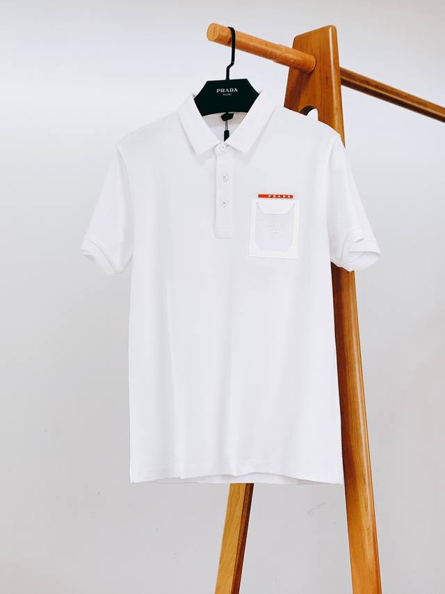 Prada 普拉达 2025Ss春夏新品 休闲翻领T恤，细节控的高阶选择 胸口红标搭配品牌经典图案，简约中带着高辨识度，不必刻意张扬，懂的人自然懂，轻松拿捏高级