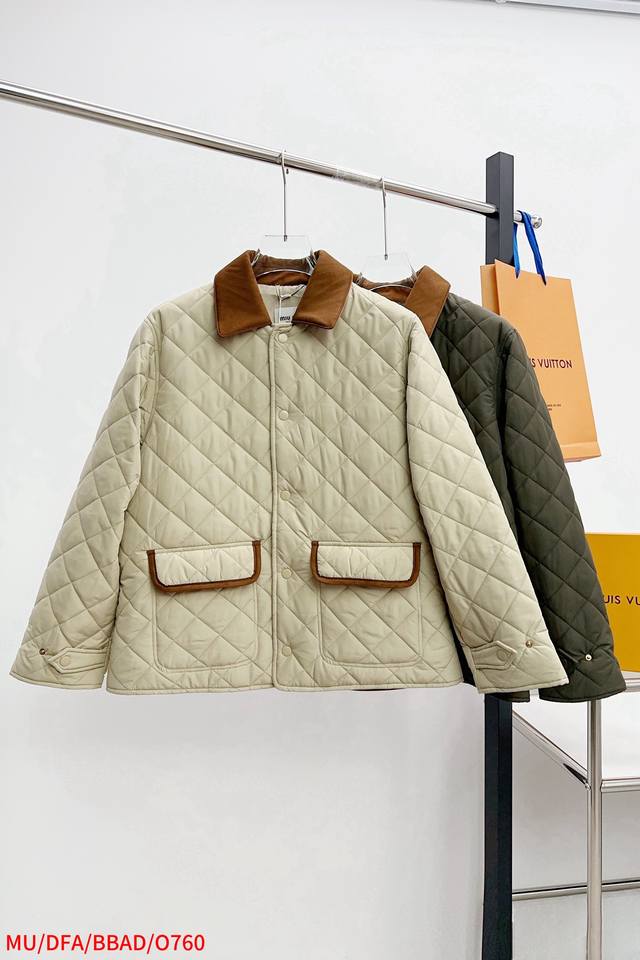 O760 Mu Miumiu 25Ss新款夹克重新诠释经典绗缝羽绒服，以轻盈的重量和柔软的宽松版型脱颖而出，与低调的绒面皮革和Nappa皮革细节的色彩和质感相得