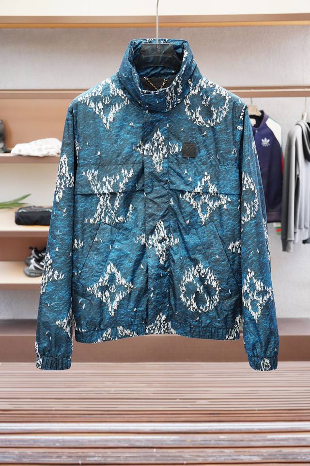 1.1高版本，产品简介 Lv 路易威登 Monogram 印花防风夹克 本款防风夹克取材轻盈科技面料，以图案描摹袖珍船队于蔚蓝水面扬帆起航的情景。橡胶贴饰点缀胸