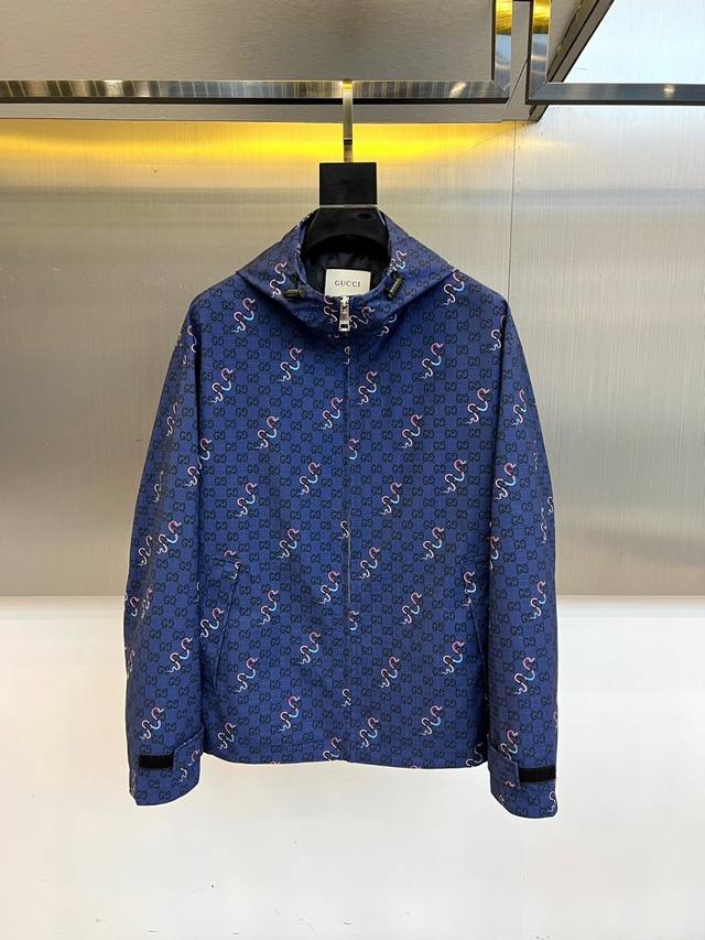 Gucc古驰、25Fw霓虹蛇纹连帽夹克外套 双G暗纹 × 霓虹蛇袭 经典深蓝底料密布Gucci标志性暗纹，粉蓝双色灵蛇蜿蜒游走，将文艺复兴的狂想注入街头基因。领