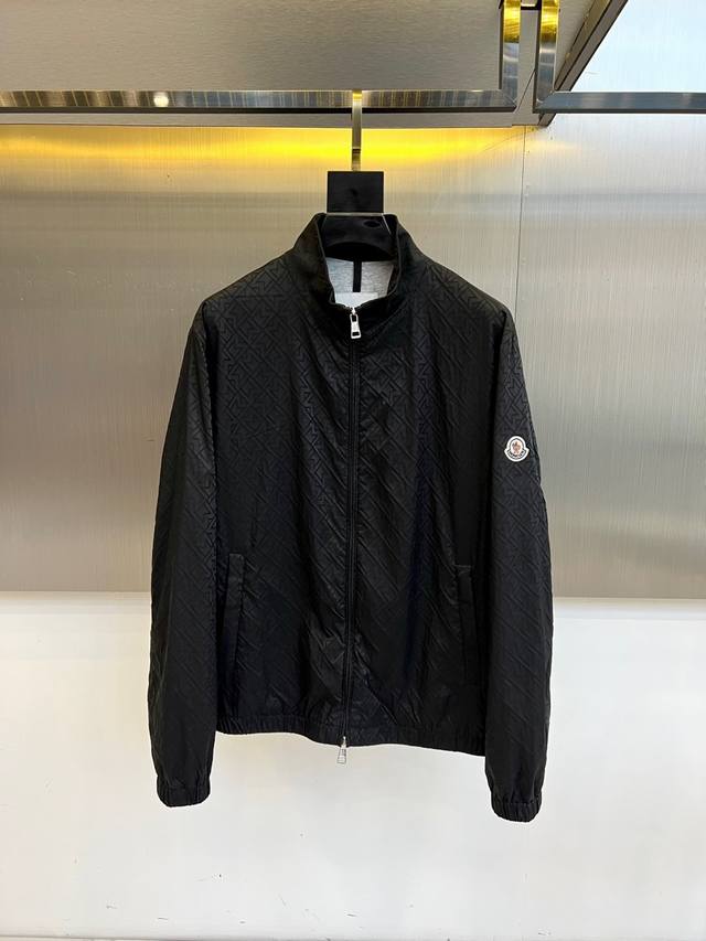 Mocler 蒙口、25S秋冬新品经典菱格纹夹克外套 纯黑哑光面料压印立体菱格暗纹，立领拉链设计搭配弹性罗纹收口，左臂珐琅彩圆形徽标彰显血统。专业黑色陈列架与金