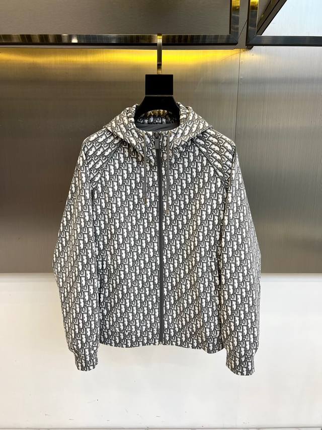 Dior 纯白底色铺满经典灰色字母印花，100%精梳棉打造亲肤质感。全拉链设计搭配可调节抽绳连帽，50码意大利精工剪裁 Made In Italy 。刺绣部分采