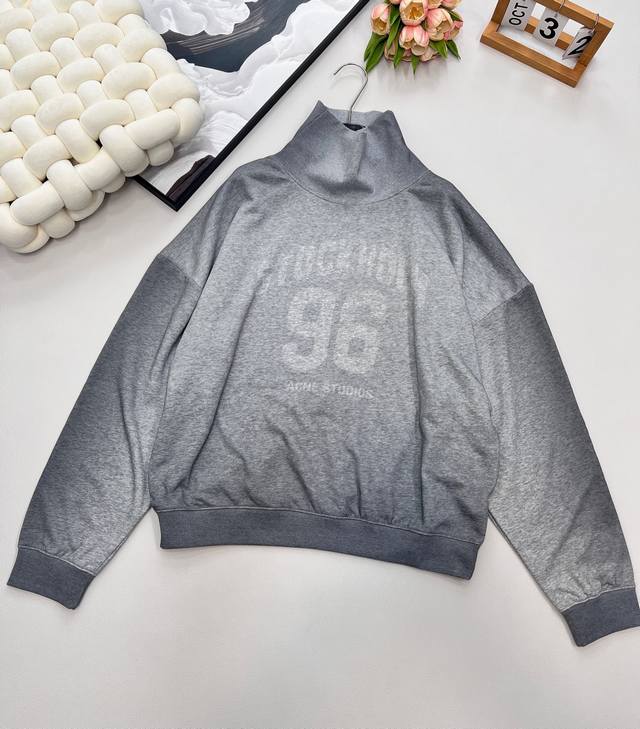 Acne Studio 渐变灰胸前96字母立领卫衣，这款Acne Studios渐变灰卫衣以低调的水泥灰迷彩为主色调，渐变效果设计充满当季潮流感。胸前中央饰有经