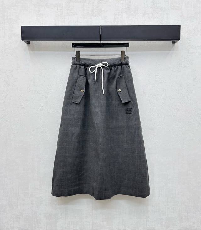 Miumi*2025新品上架 格纹抽绳半裙 定制Yb进口斜纹棉材质 垂顺舒适 挺阔有型 沿用撞色抽绳调节方便穿脱 配合翻盖口袋纽扣设计 增添造型层次感 通体满印