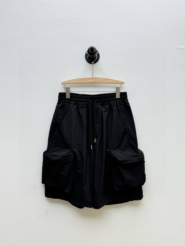 Loe 徽标印花尼龙工装短裤、代工厂P出品 夏季新品 单品以功能性为核心，同时融入品牌标志性的艺术化表达 两侧的立体隐藏拉链口袋延续工装传统，强调收纳功能，而抽